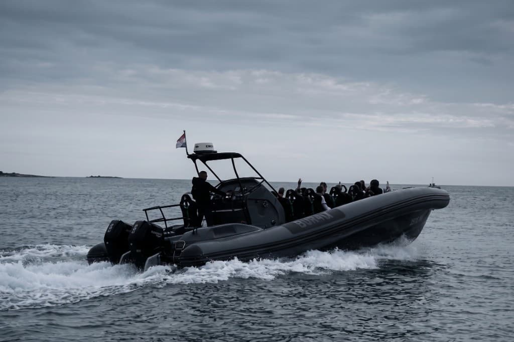 Bura-X crni visokoučinkoviti RIB s putnicima na palubi, juri tamno plavim morem